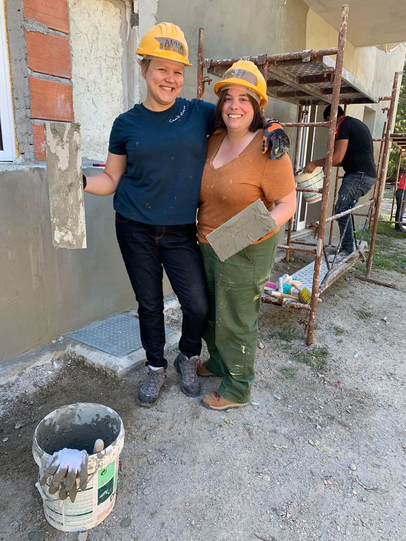 Two Women pose in their construction gear on their honeymoon at a Habitat for Humanity build