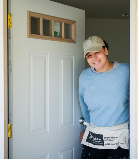 Habitat for Humanity new homeowner, smiling as she opens her door