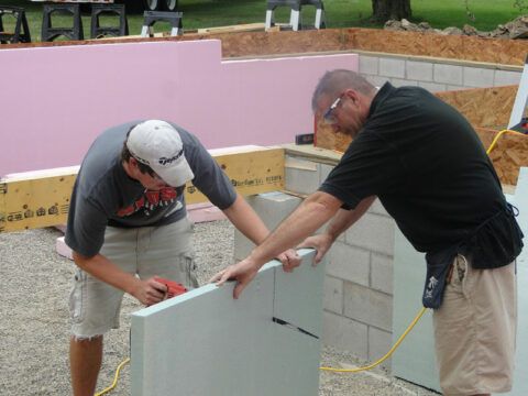 Whirlpool employees installing insulation in a Habitat home