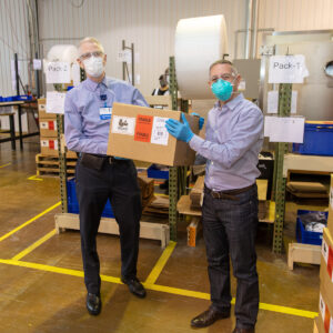 Dr. John Froggatt III receives the first box of PAPR units from Christian Gianni