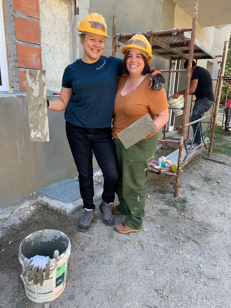 Two Women pose in their construction gear on their honeymoon at a Habitat for Humanity build