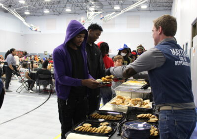 volunteers serving kids a pre-Thanksgiving Day meal at Boys and Girls Club
