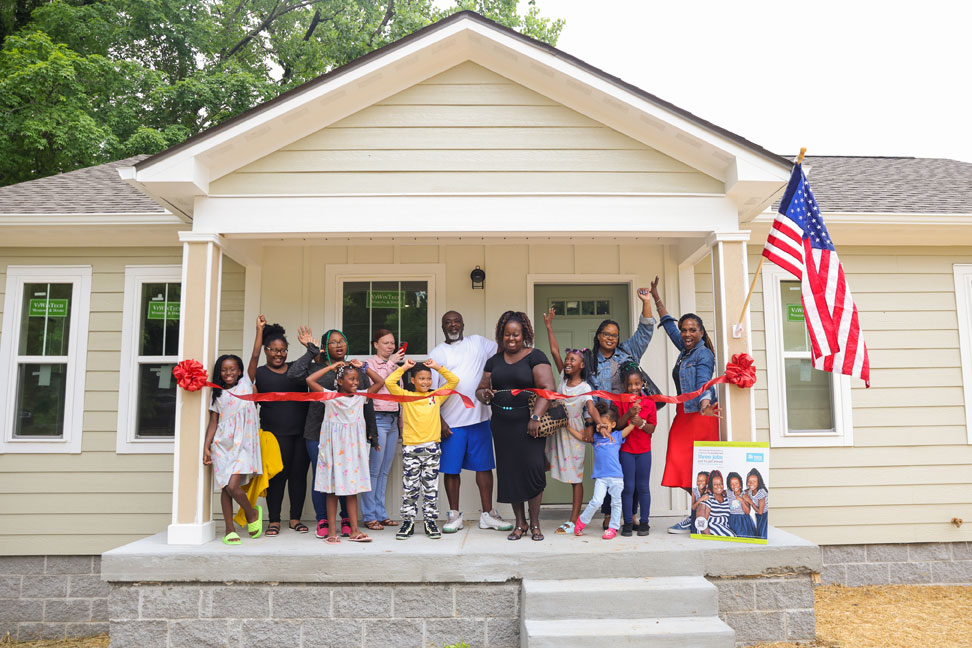 LaTonya cutting the ribbon to her new Habitat home, celebrating with friends and family